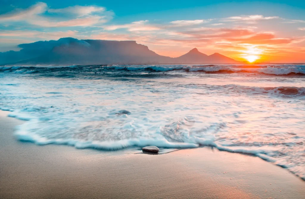 AI Search Visibility Cape Town: Getting Cited by AI (Close up of a wave hitting the sand on a beach with tabel mountian in the background)