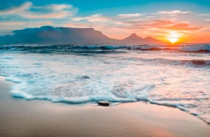 AI Search Visibility Cape Town: Getting Cited by AI (Close up of a wave hitting the sand on a beach with tabel mountian in the background)