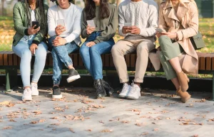 Influencer Marketing Pricing in South Africa 2026 (A group of young people sitting outside and looking at their phones)