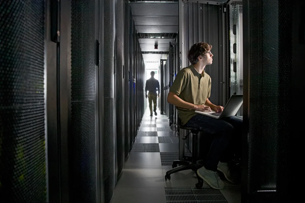 AI Incident Knowledge Base for MSPs (Technician working in a server room on their laptop)