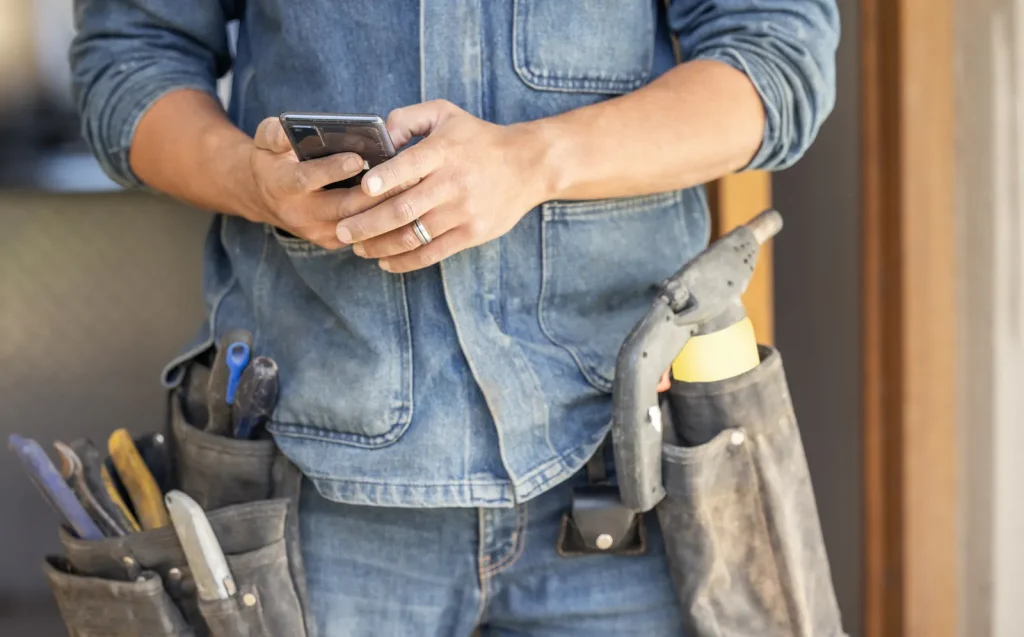 How to Set Up WhatsApp Ads in South Africa 2026 (tradesman checking his phone while on the job)